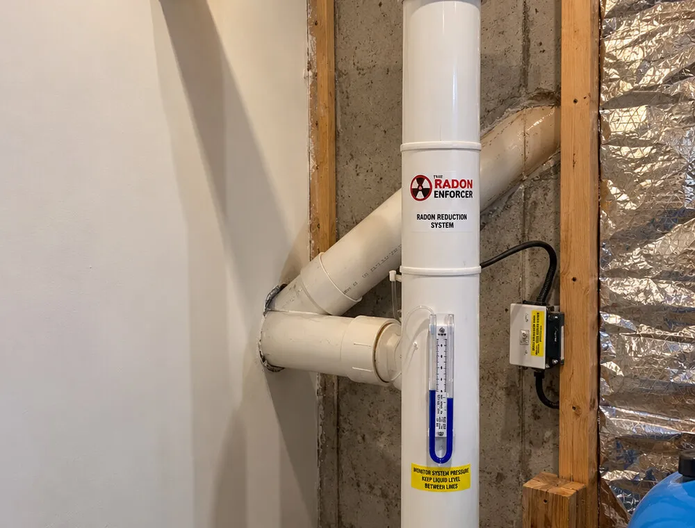 Interior radon reduction system piping and U-tube manometer